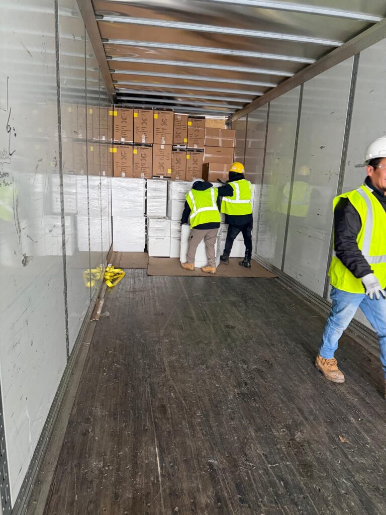 Manova Services commercial moving crew loading wrapped office items into a truck