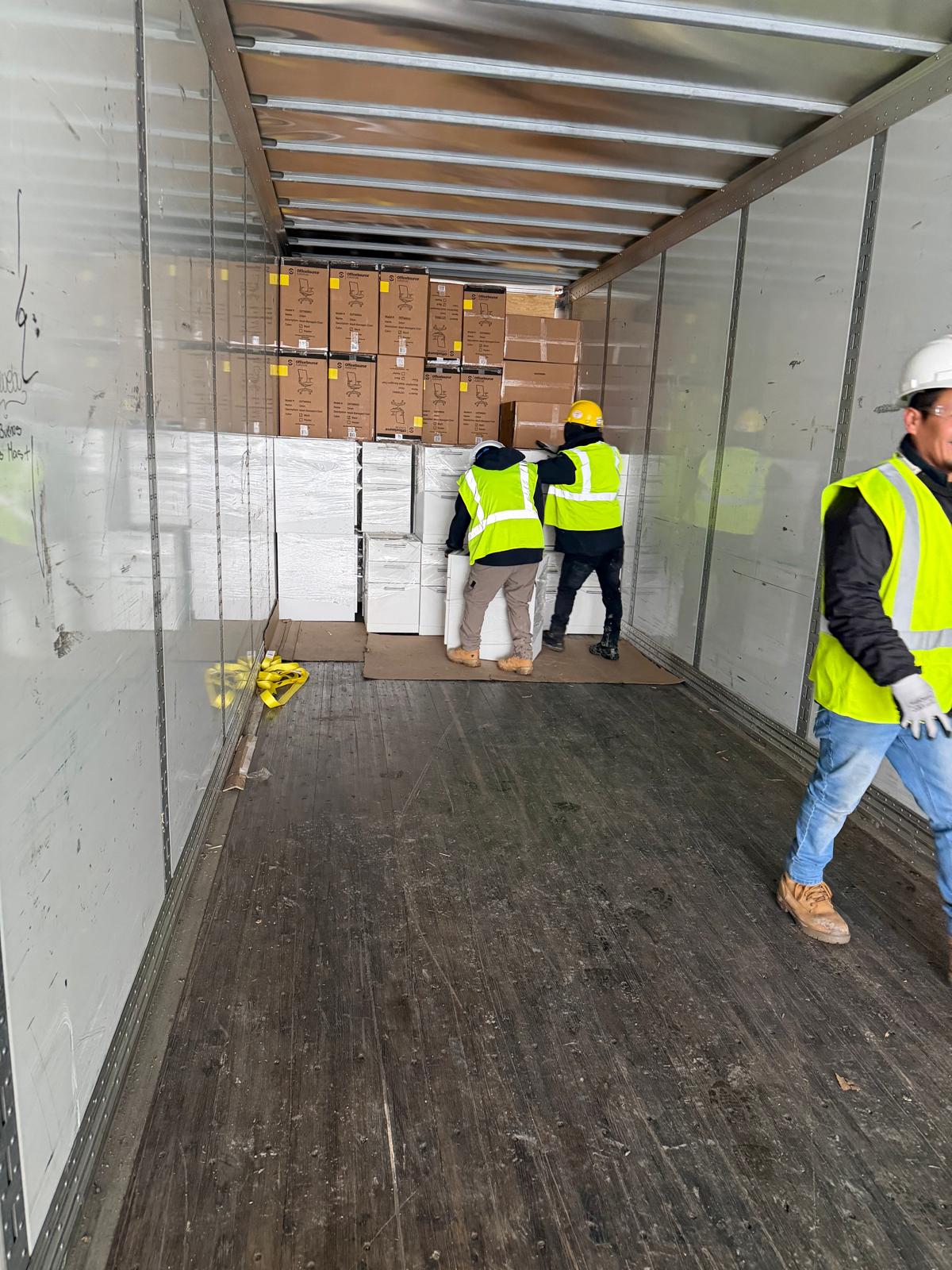 Manova Services commercial moving crew loading wrapped office items into a truck