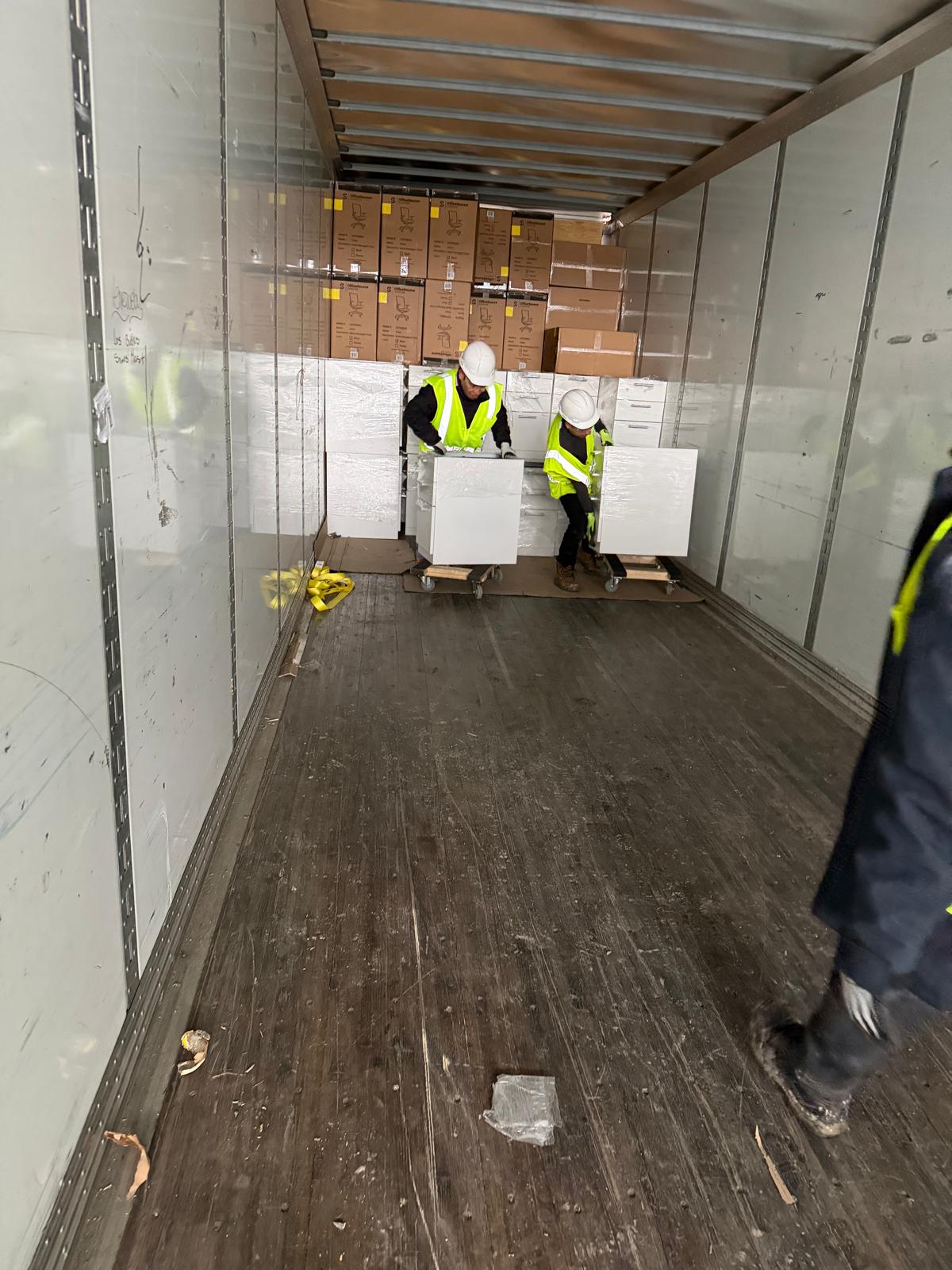 White-Glove Office Moving – Manova Services Manova Services crew moving a wrapped office item inside a box truck
